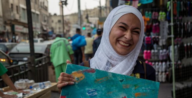 17-year-old Jordanian girl with one of her paintings. Photo: Nathalie Bertrams/GAGE