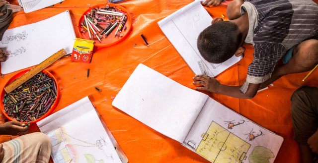 Rohingya children drawing pictures of what they witnessed in Myanmar. Photo: Anna Dubuis/DfID