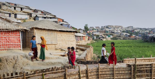 Refugees walk on an elevated footpath in Chakmakul camp © European Union 2018